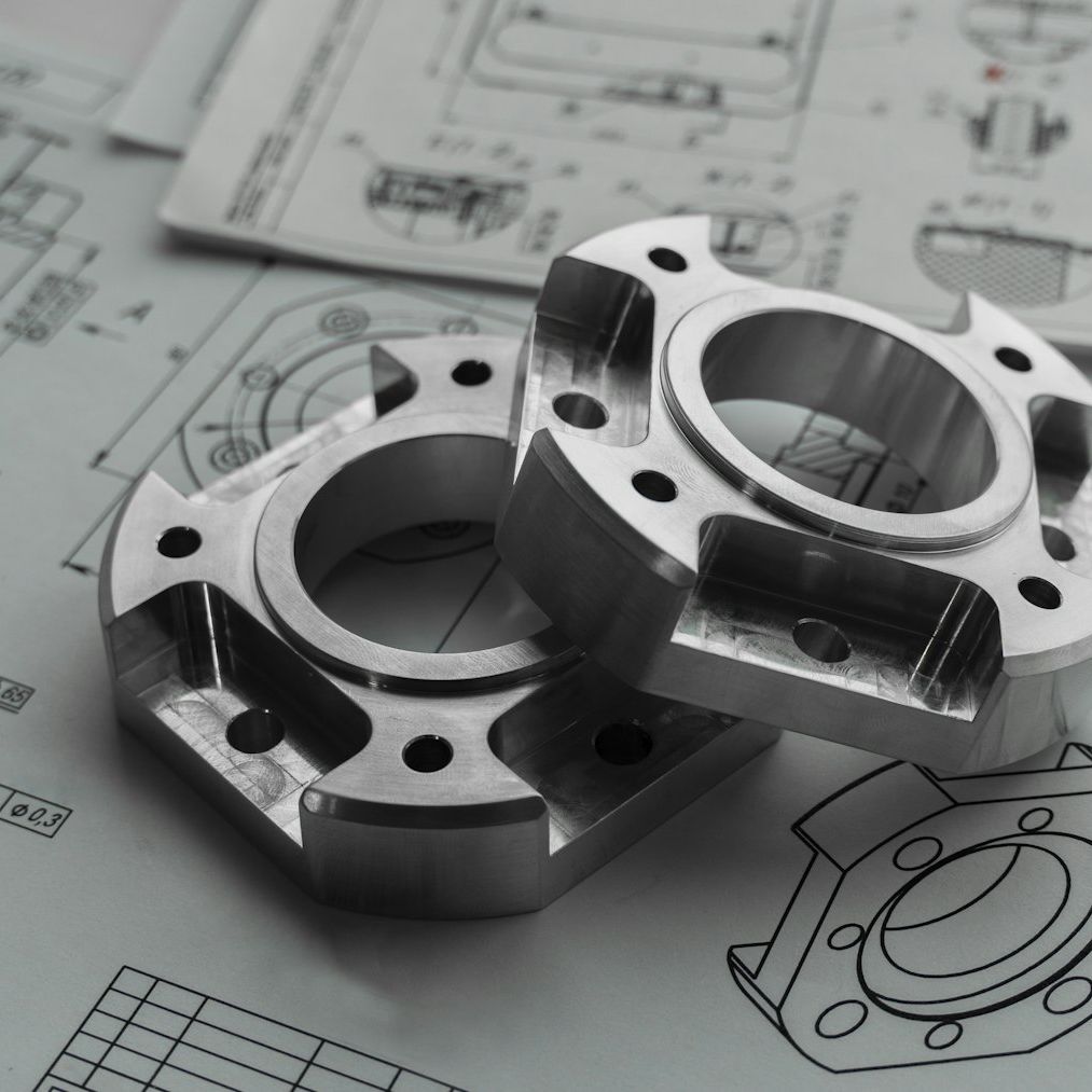 Machined metal parts on technical drawings.