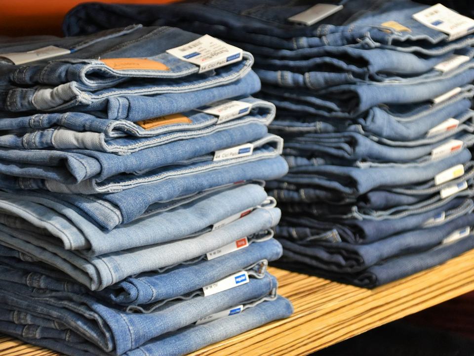 Stacks of folded jeans ready for wholesale.